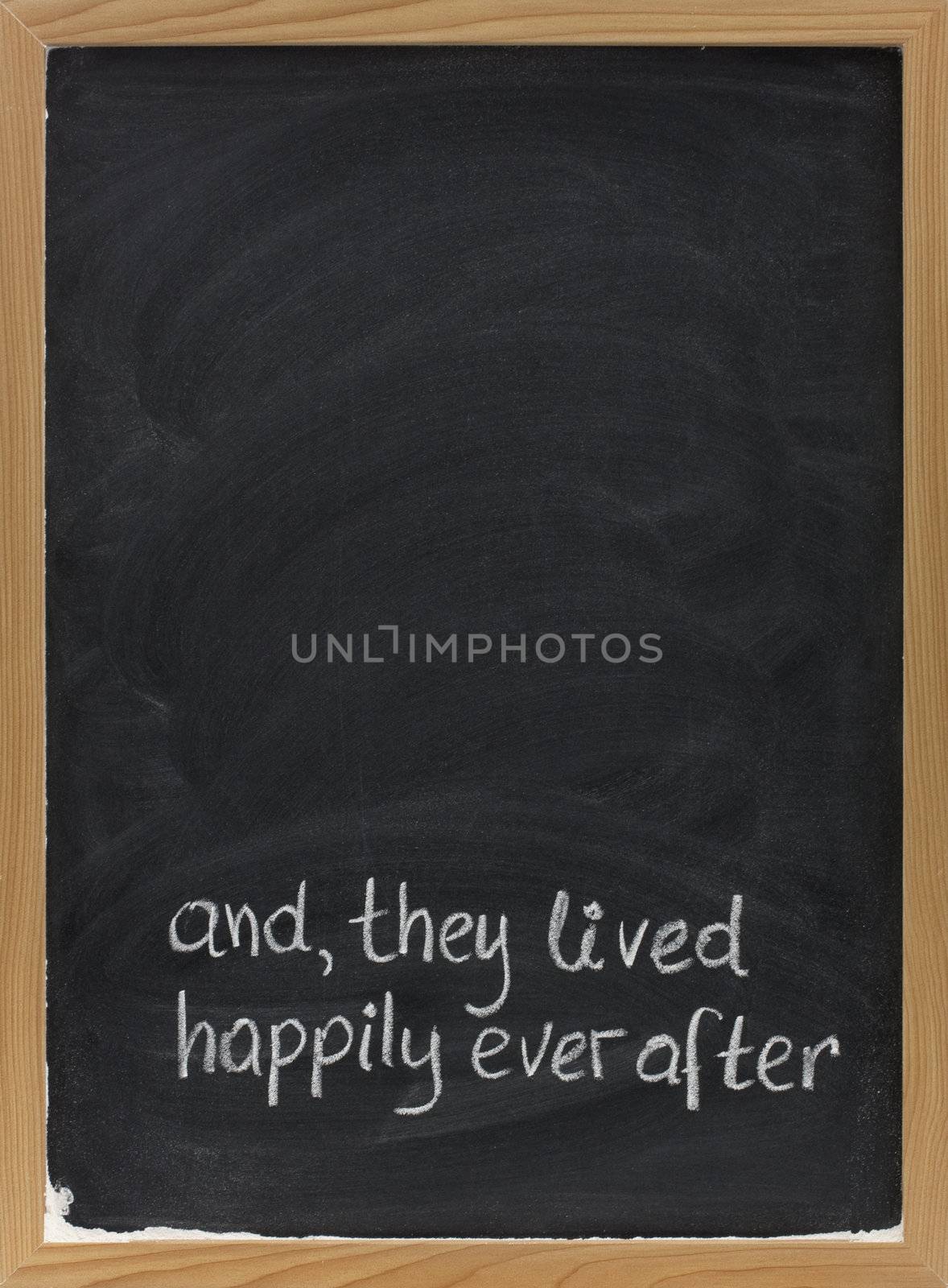 and, they lived happily ever after -  stock phrase for ending oral narratives or fairytale handwritten with white chalk on blackboard, copy space above