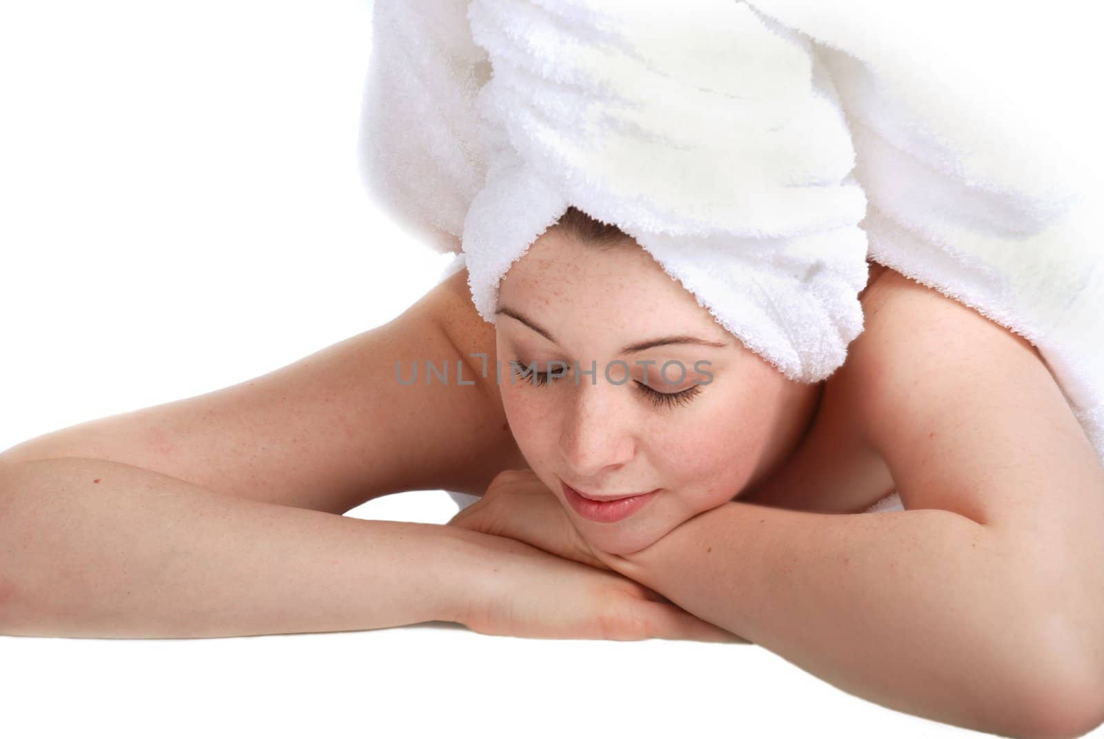 Pretty girl laying down, hair wrapped in a towel. Spa theme.