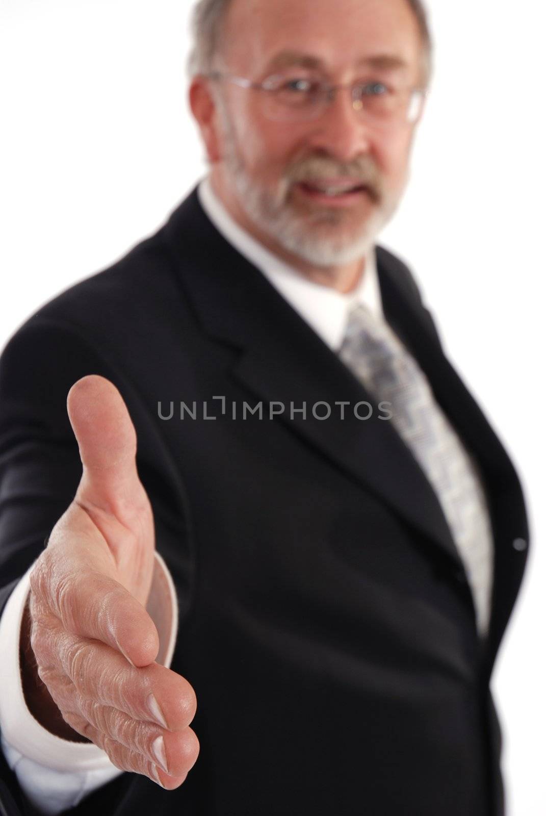 Senior businessman holding out hand for a hand shake. Focus on hand