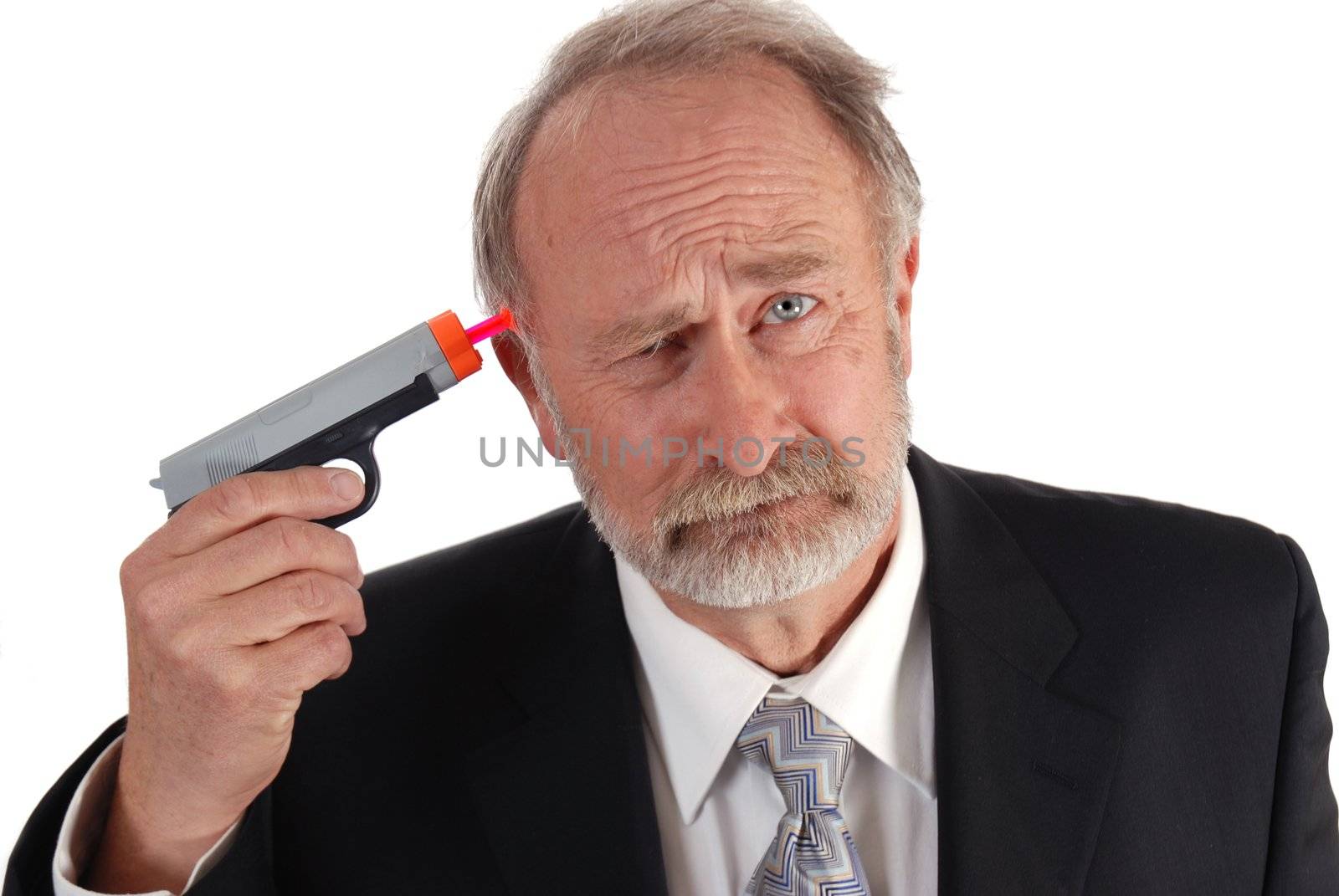 Businessman with a dart gun to his head looking depressed. Poor business theme.