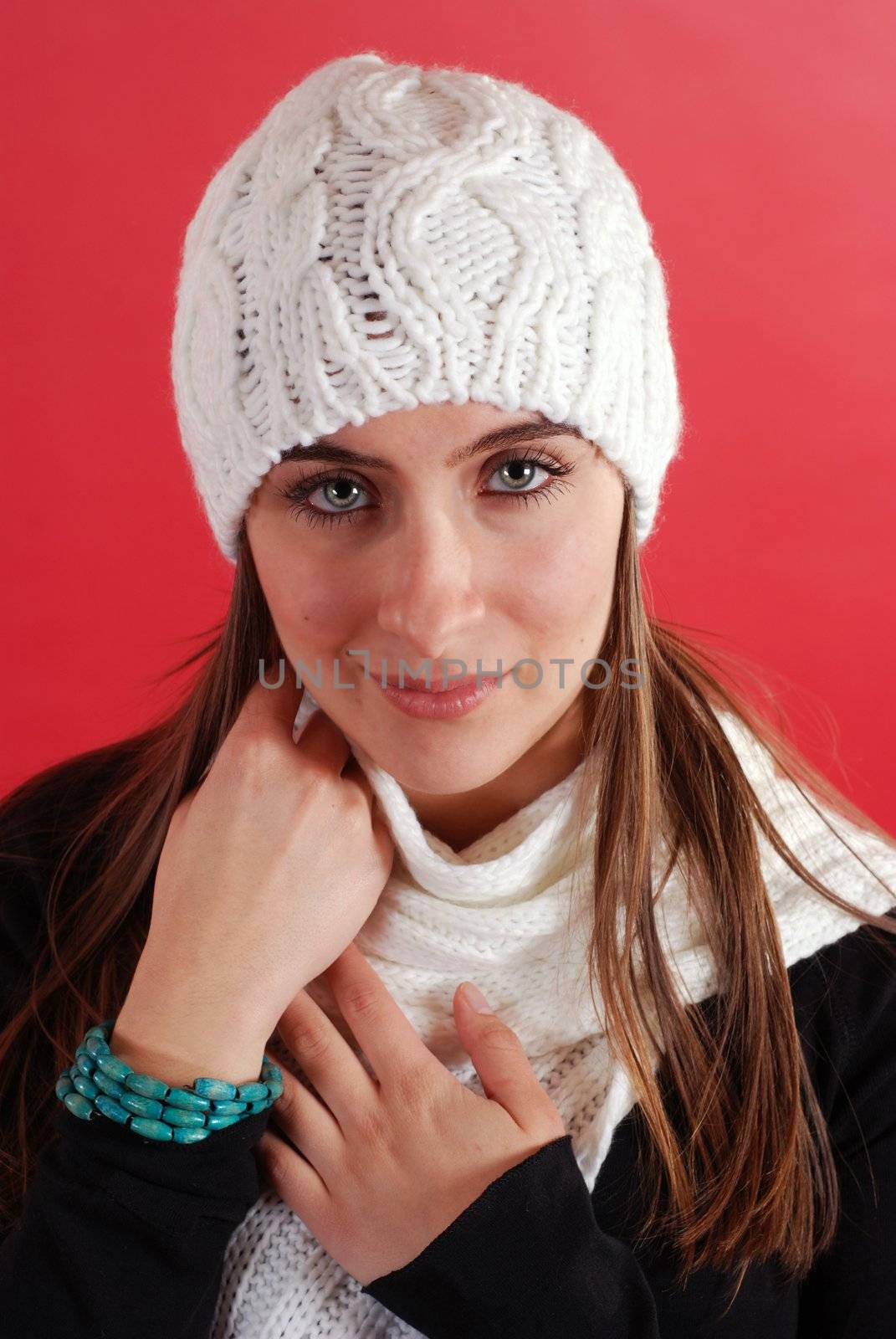 A Beautiful woman wearing a tuque and sacrf on red.