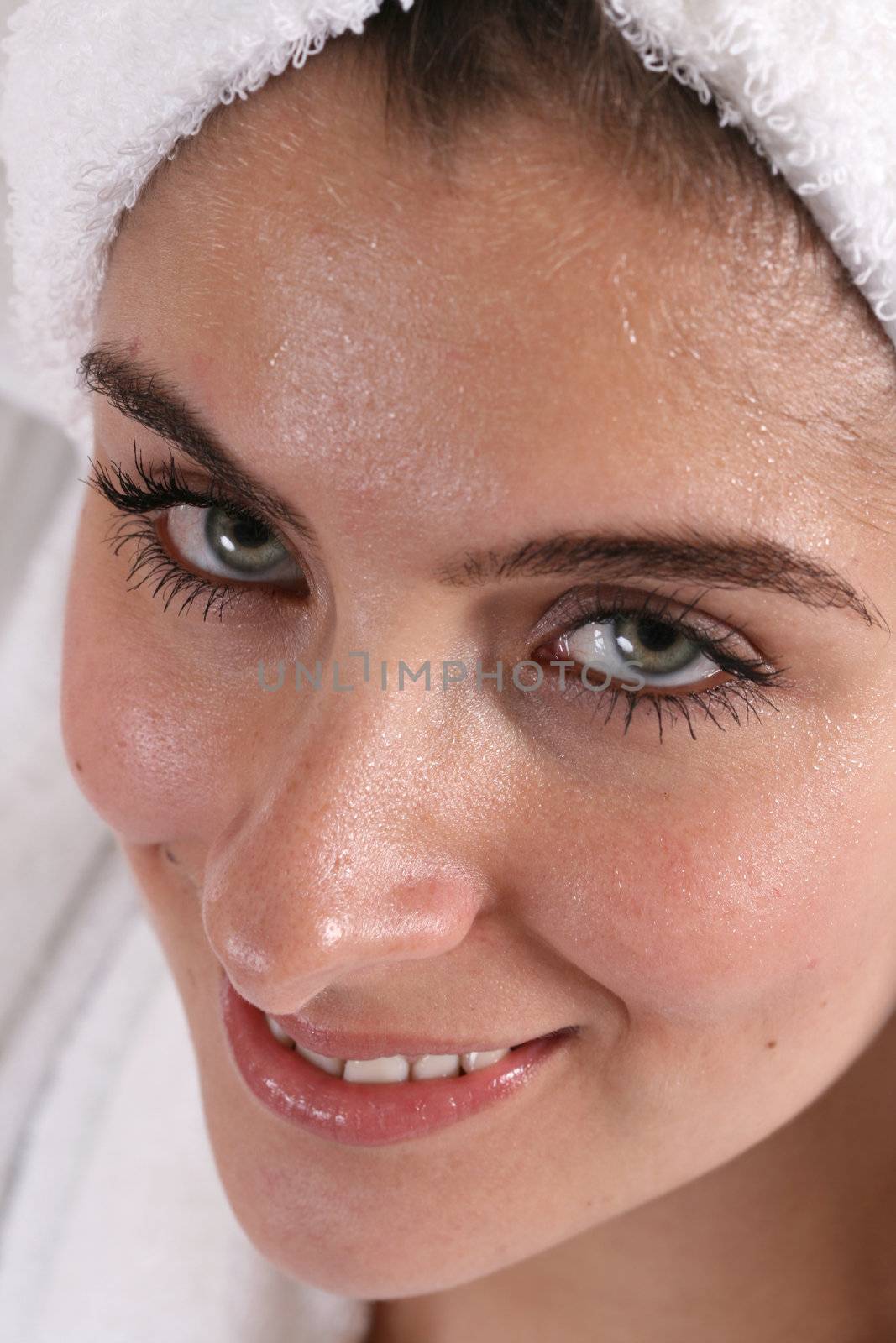 Woman with wet face and hair in a towel