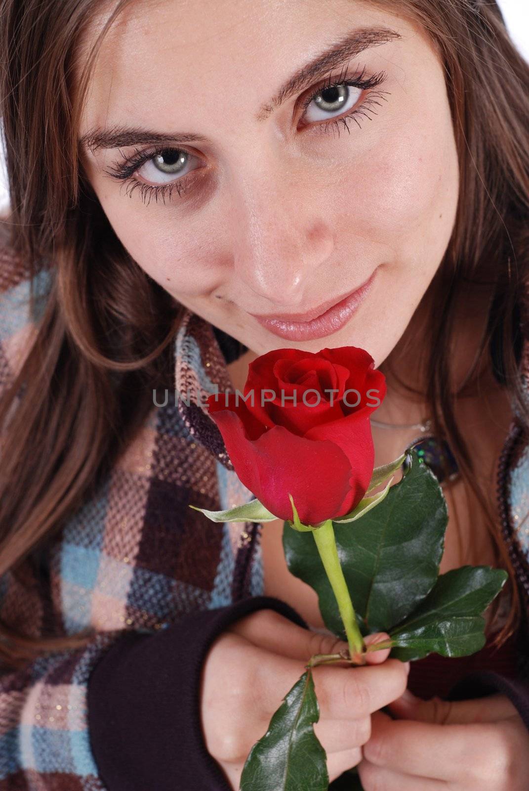 Beautiful woman in plaid coat smelling a rose