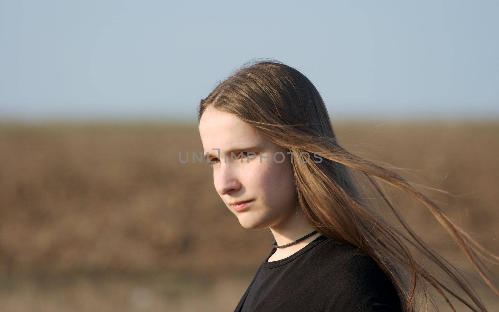 Girl with long hair walking on a field