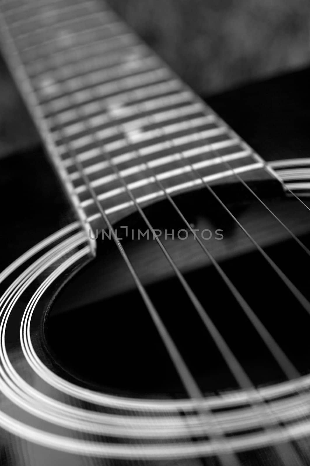 Detail of a black acoustic guitar in black and white