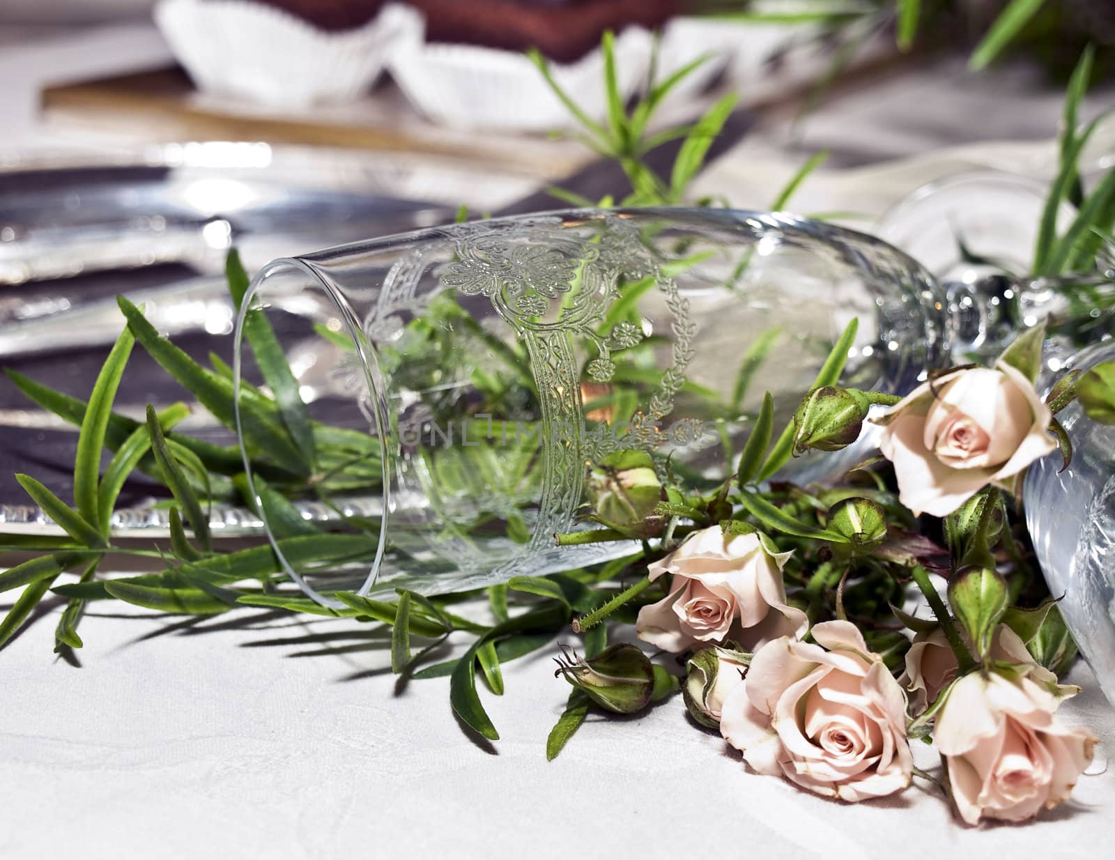 Close up of a wedding champagne glass lying on baby roses