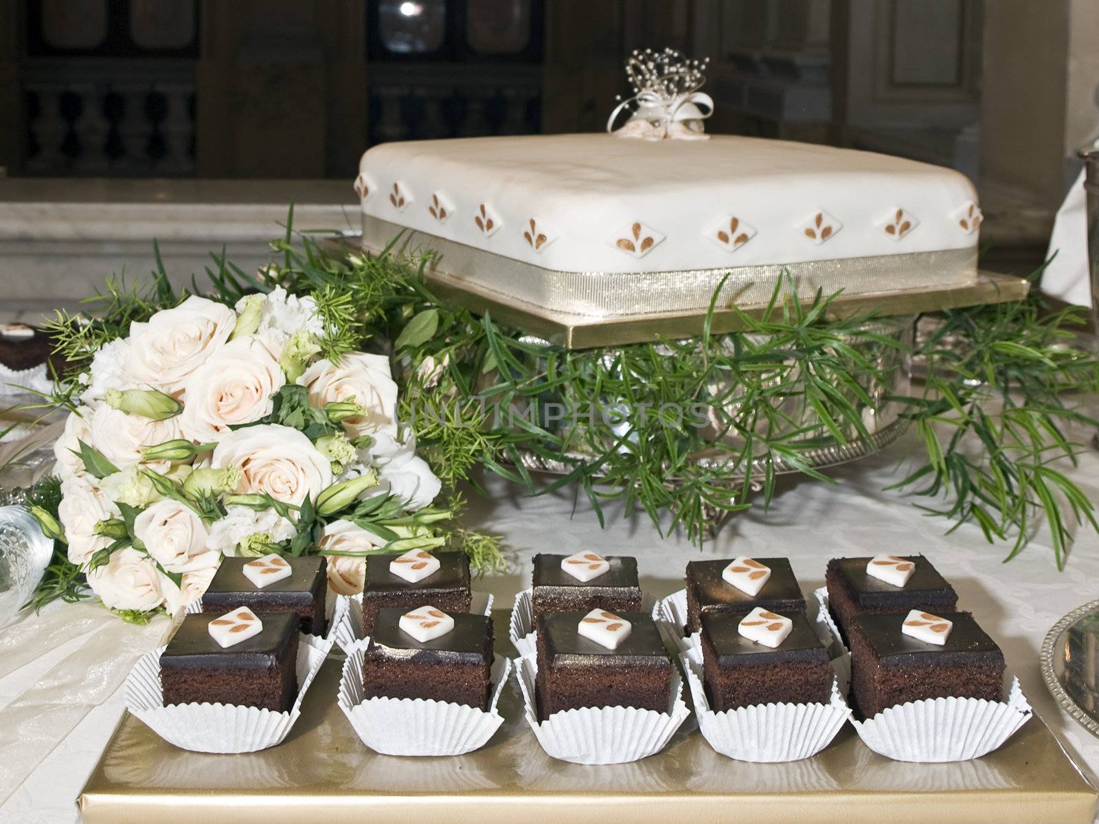 Wedding chocolate cakes and main wedding cake with bridal bouquet