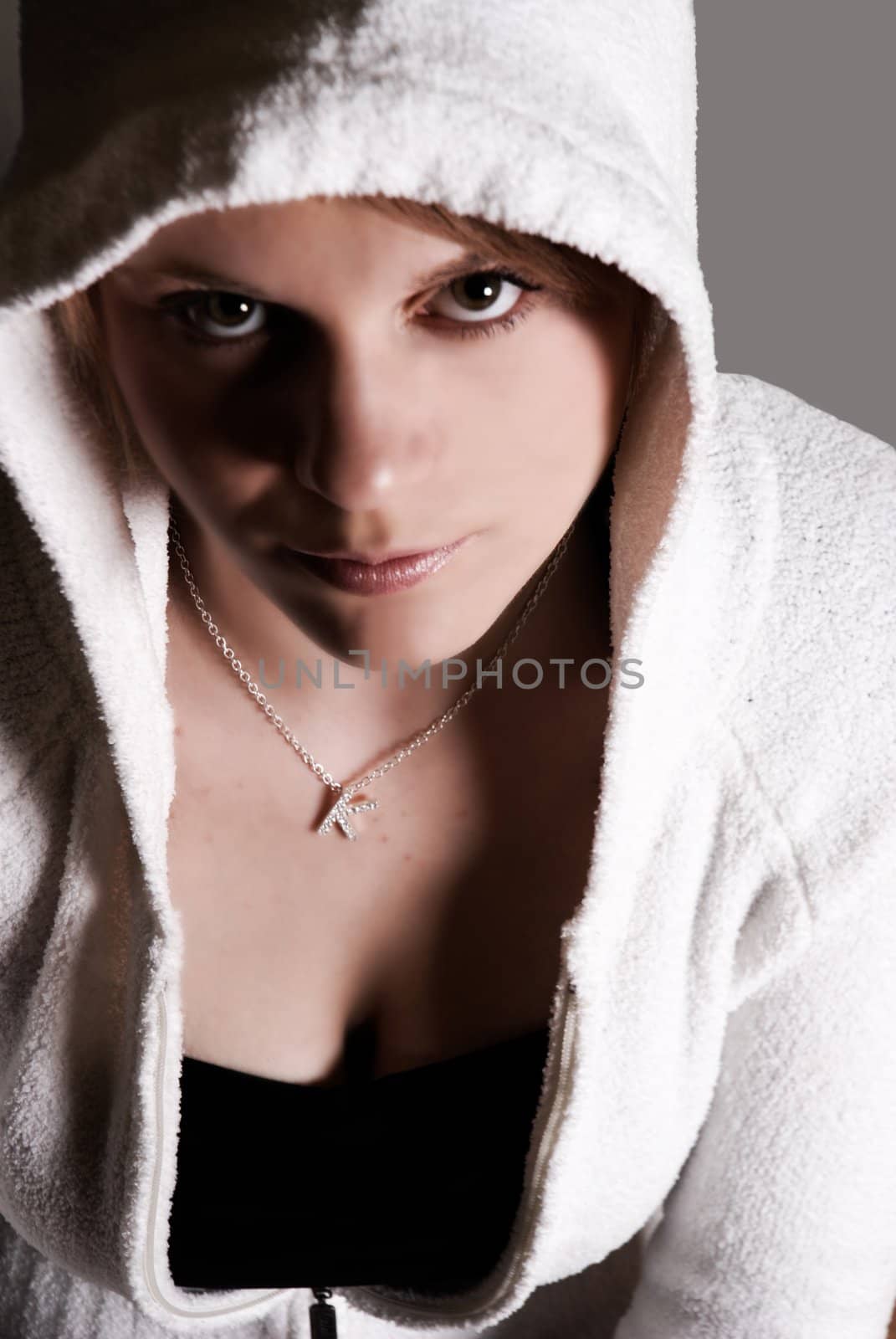 Harsh shadows on a girl in a hoodie. Grunge theme.