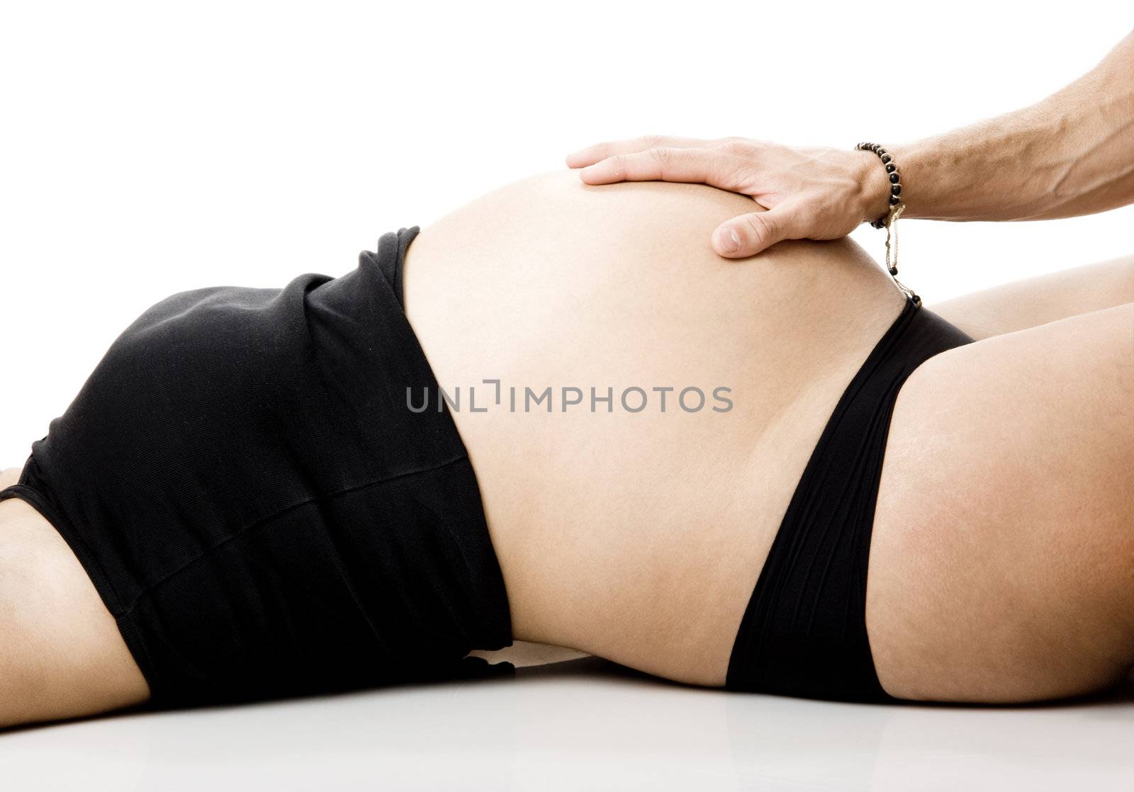 Man hand touch the tummy of a nine months pregnant woman 
