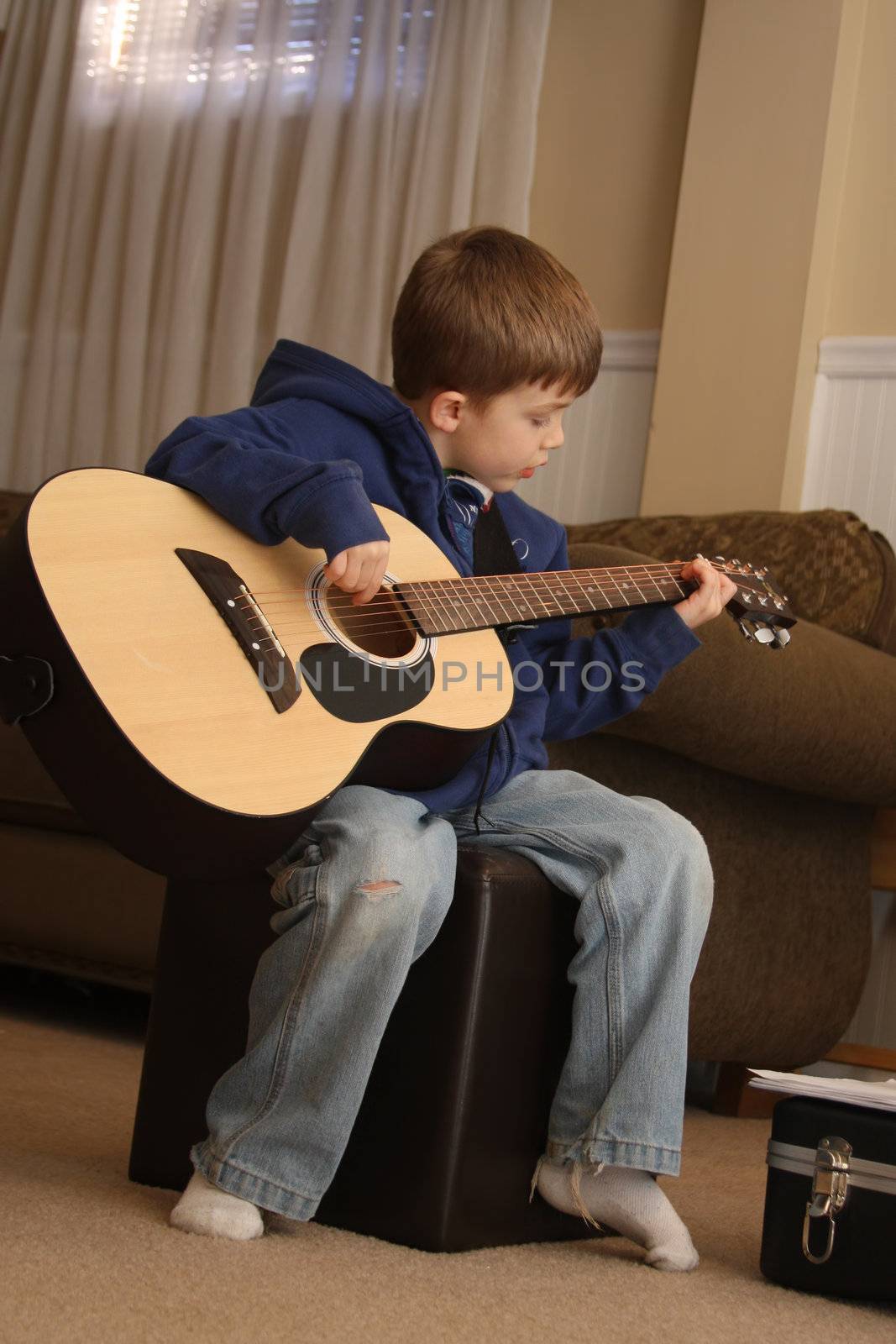 Young Boy playing the guitar during lessons.