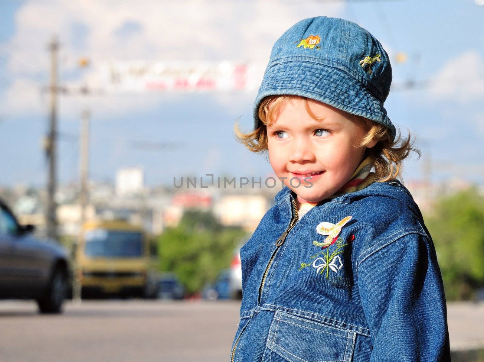 little girl is standing close to the road with heavy traffic. Parents be careful 