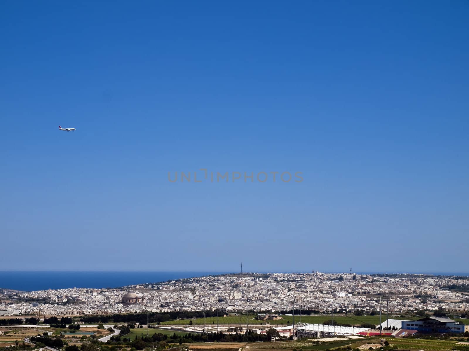 View of Malta as seen from Mdina bastions with plane on final descent to Luqa Airport