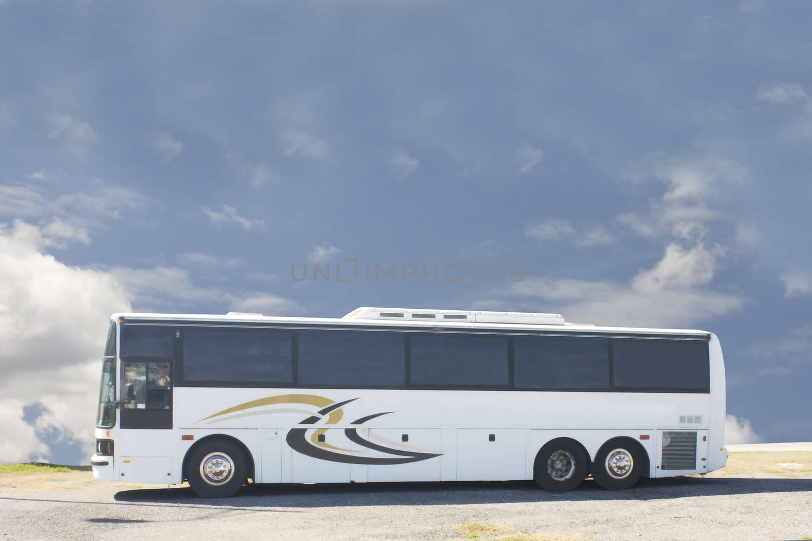 white tour bus against a blue cloudy sky