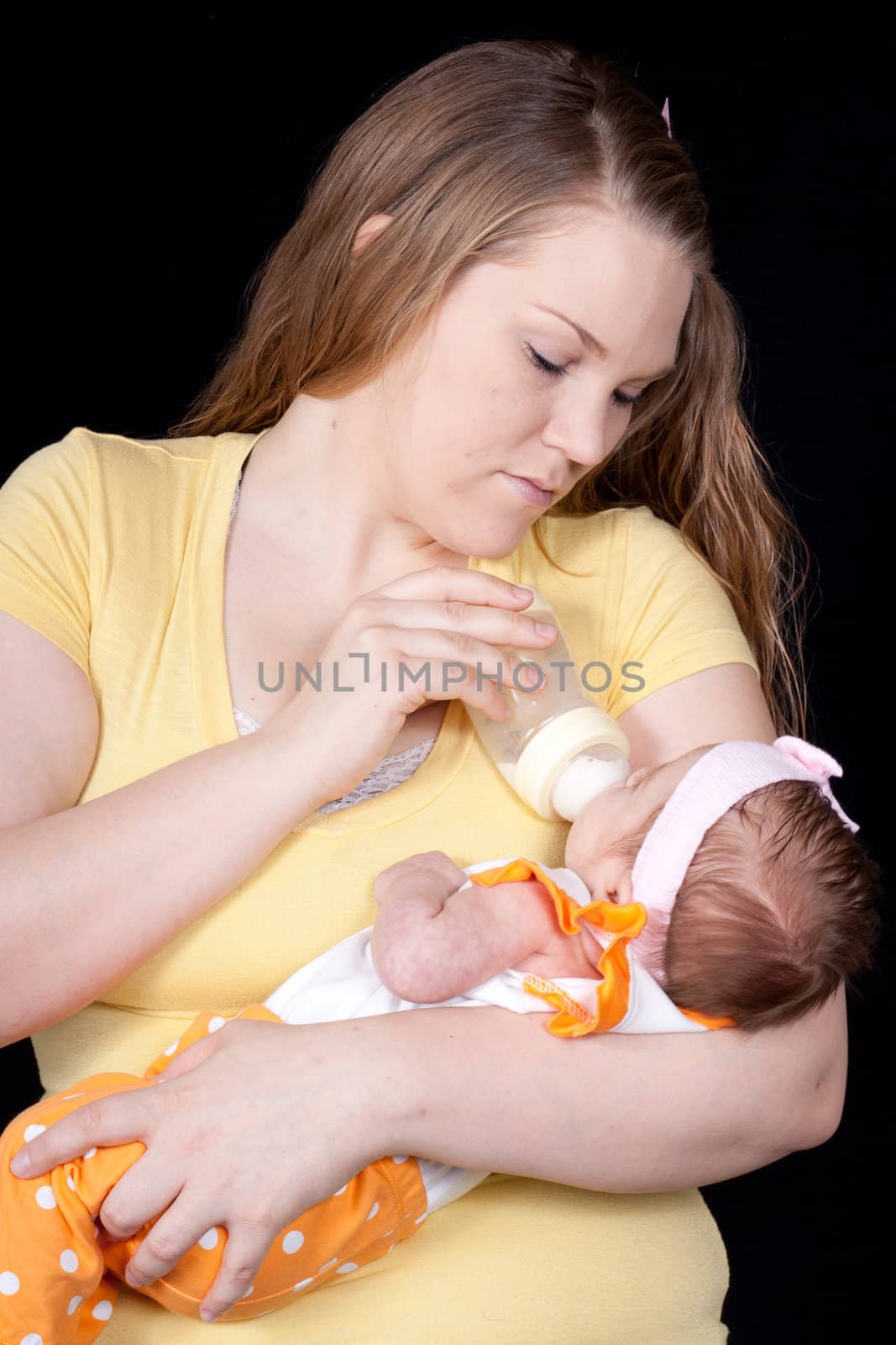 A mother feeding her baby out of a bottle.