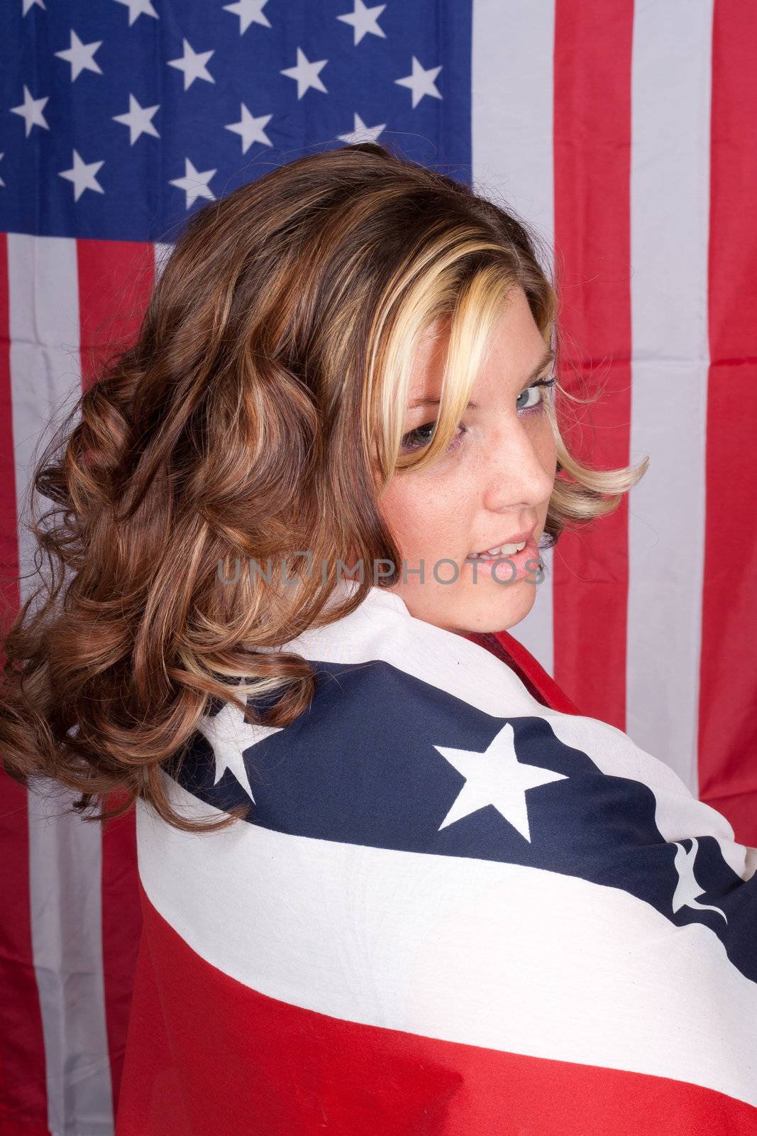 A photograph of an American lady with the American Flag in The Background.