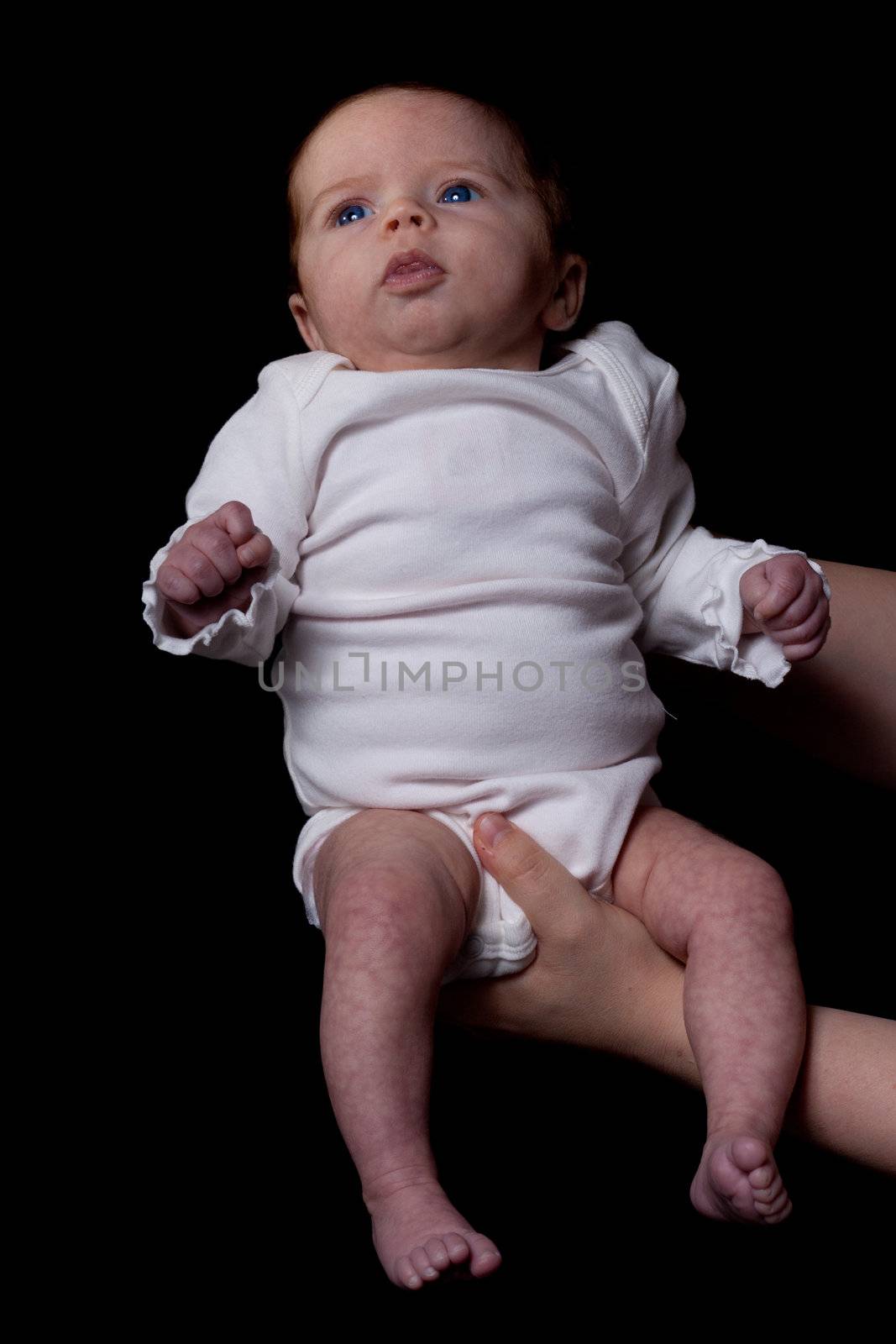 A mother raising her baby up to the light.  The photograph is side lit to add emotion to it.