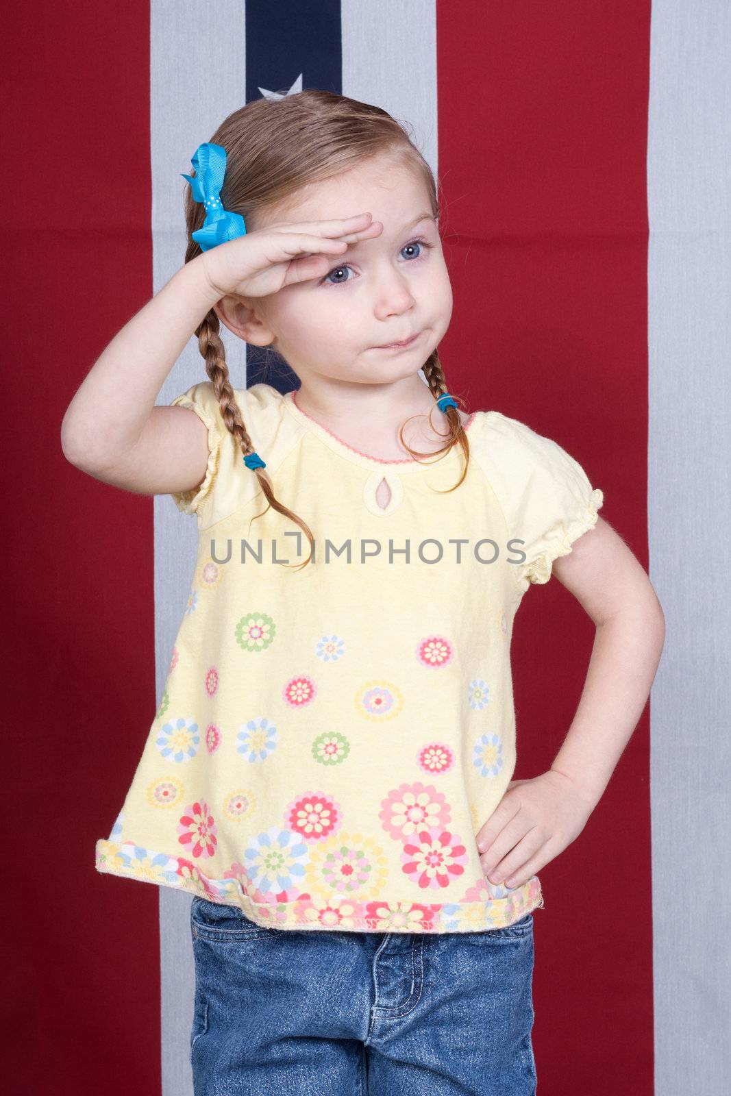 Cute girl saluting with a patriotic design in the background