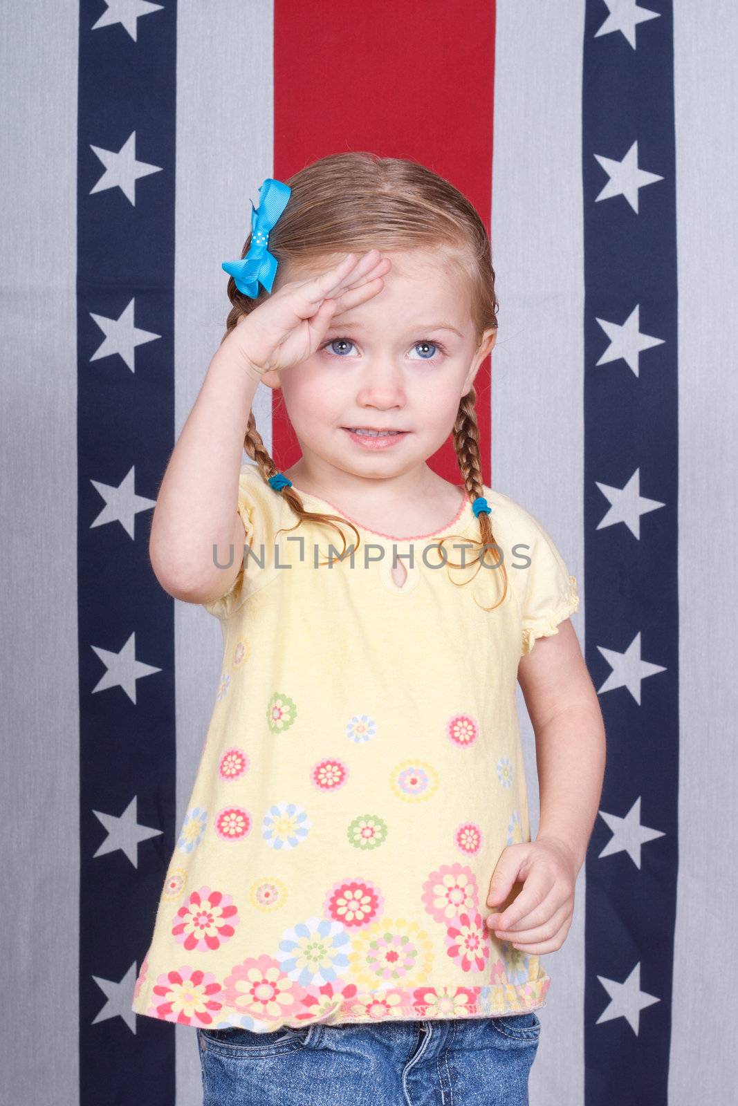 A girl saluting the viewer.  The viewer is taller then her, it could be a parent.