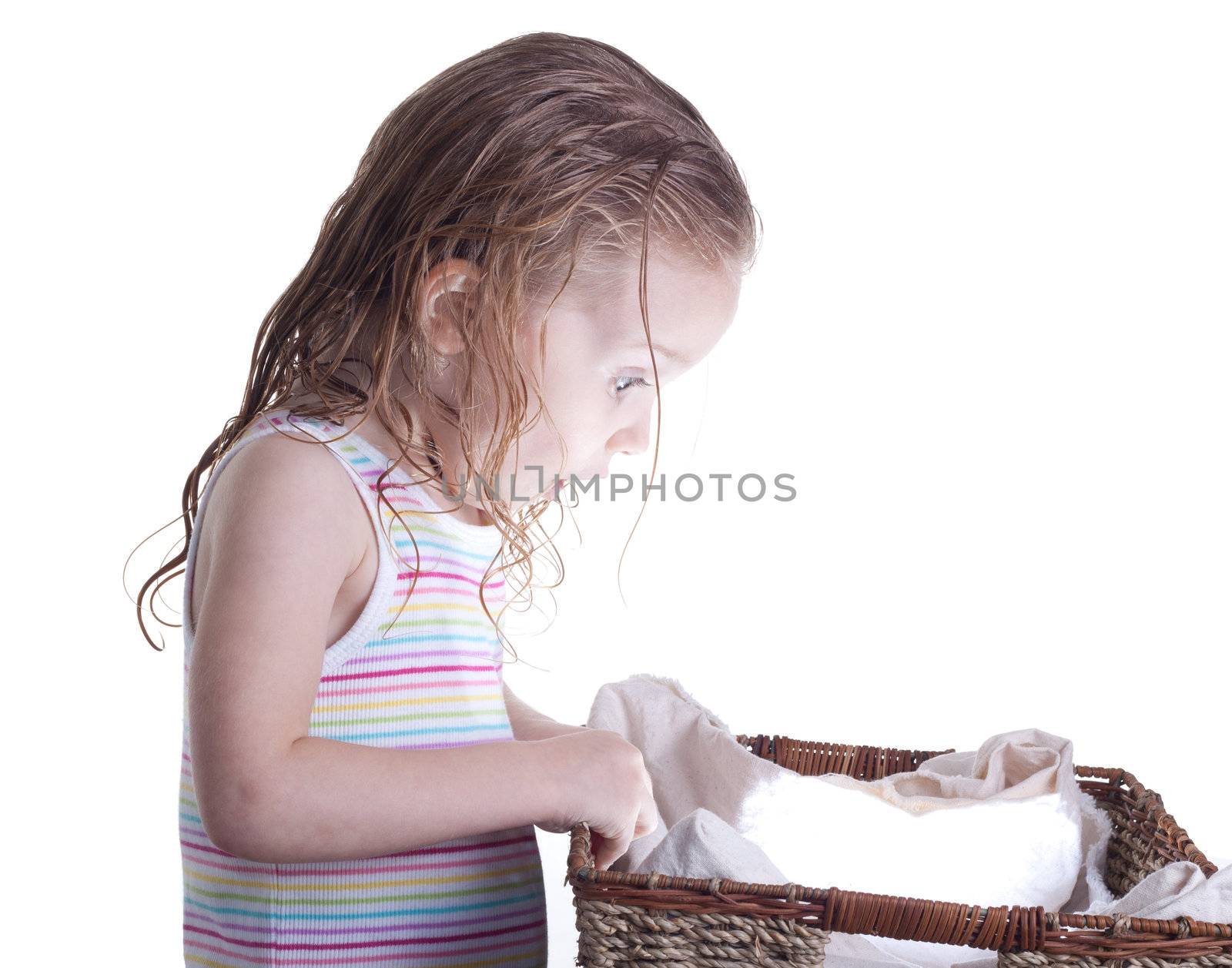 An excite young girl looking into a basket.  The basket is glowing with a ball of light or something inside of it.