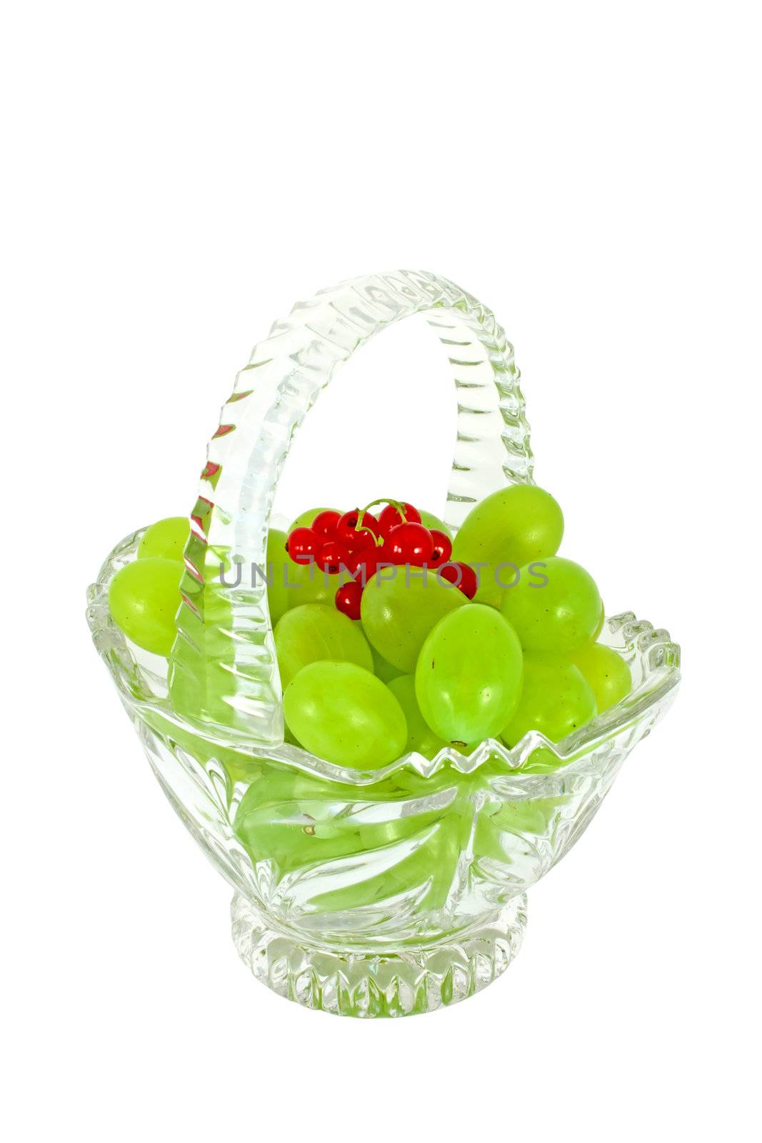 Glass basket full of fresh grapes and currants isolated on white