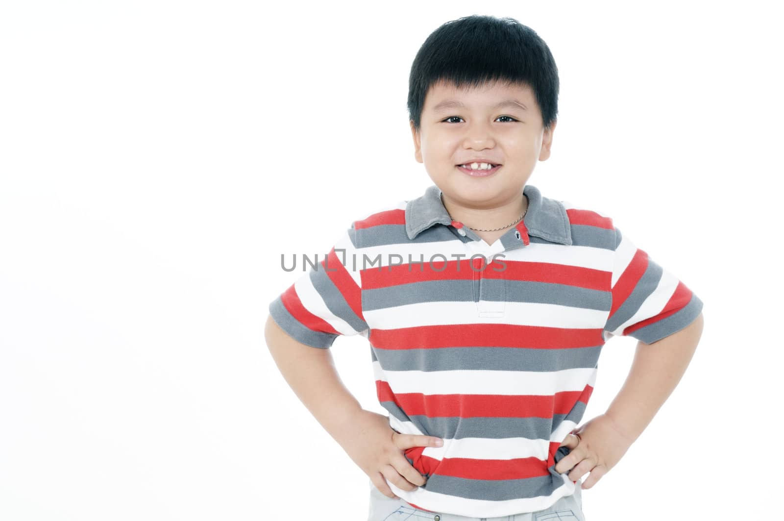 Portrait of a happy young boy with hands on his hips.