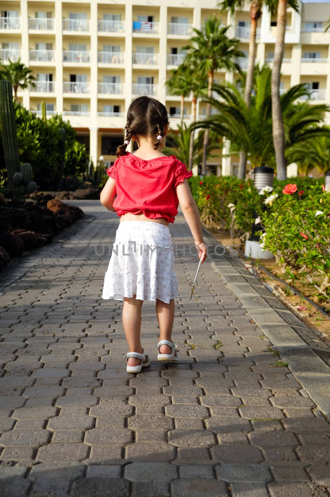 Young child walking with hotel key in her hann