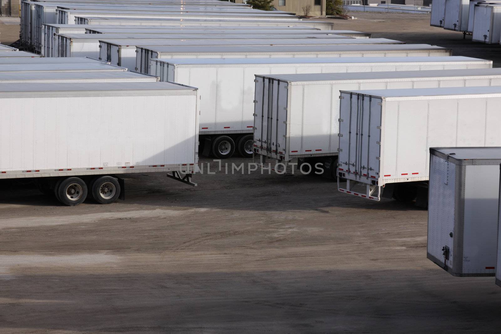 A parking lot with lots of transport trucks and trailers.
