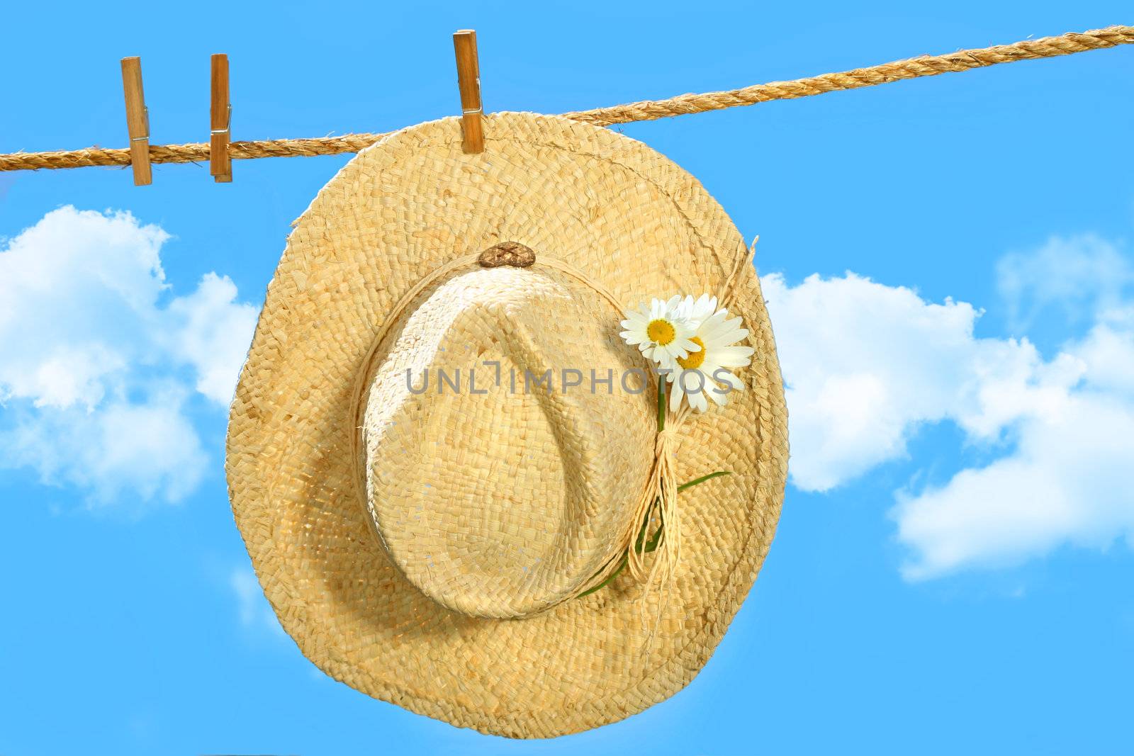 Straw hat on clothesline with blue sky