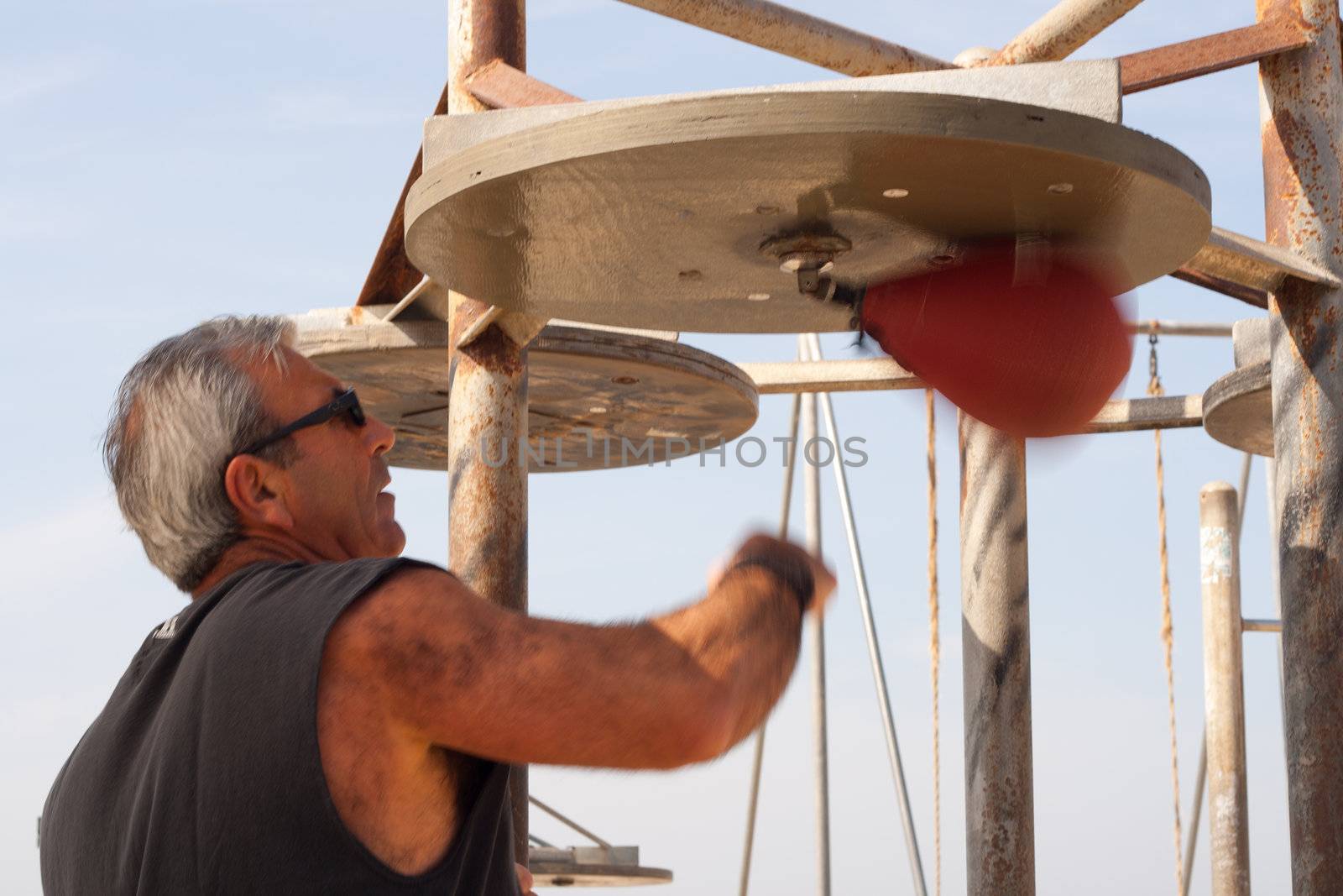 An old retired boxer punching a speed bag.