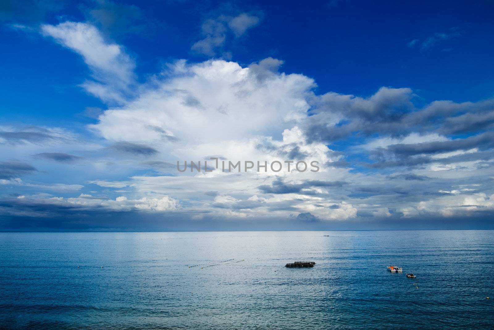 It is beautiful sky and ocean with fishing boats.