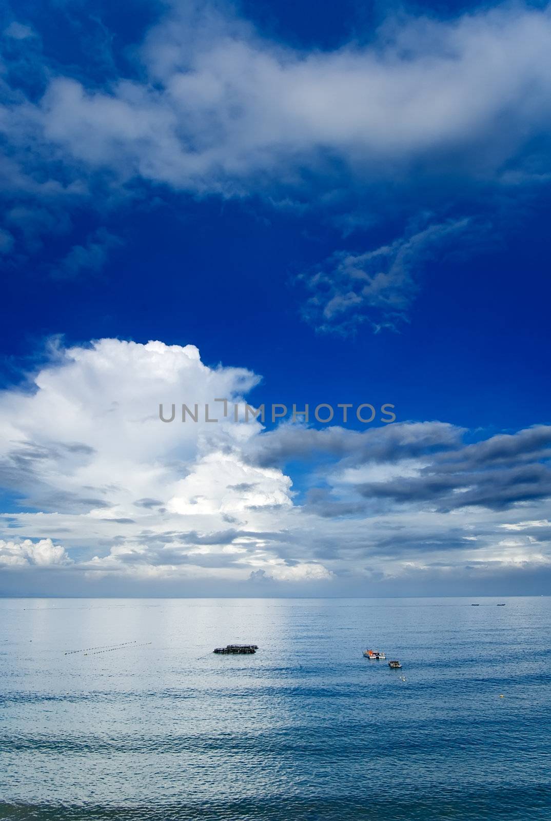 It is beautiful sky and ocean with fishing boats.