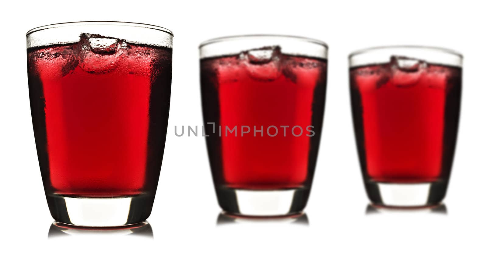 Three glasses of red fruit juice with ice on white background
