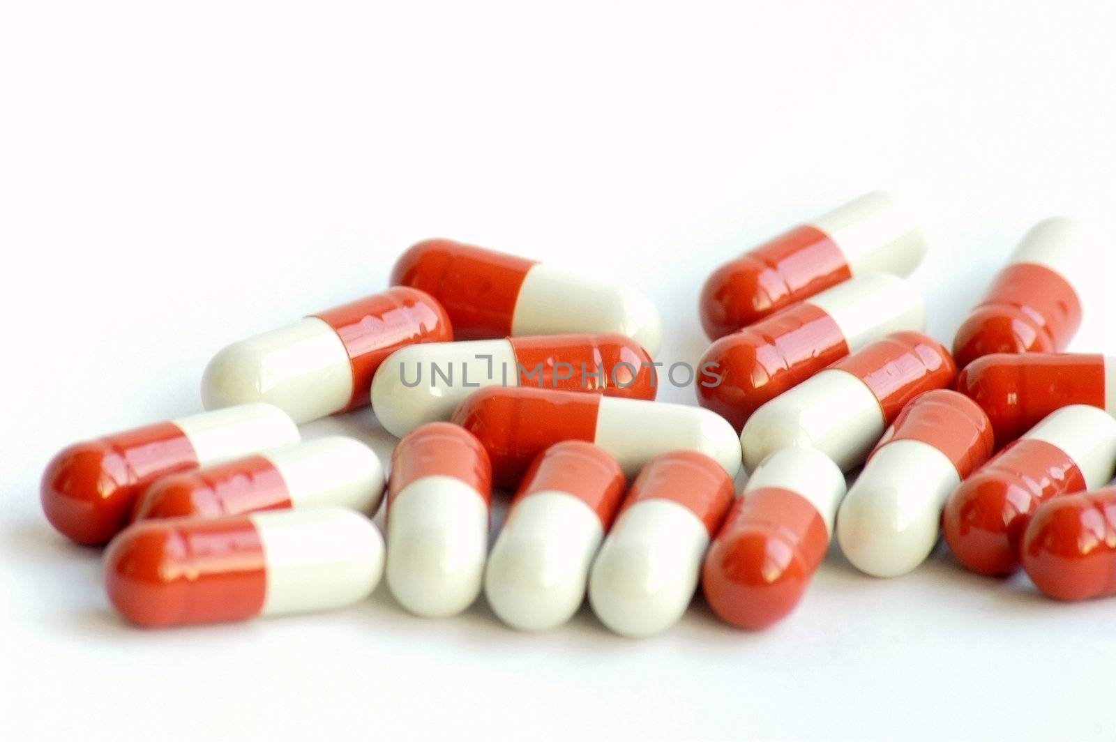 Closeup view of red-and-white medicine capsules on white background