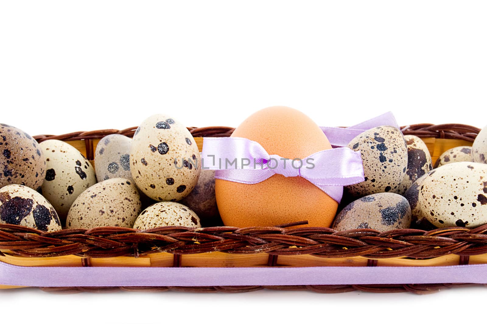 Quail and chicken eggs in basket over white