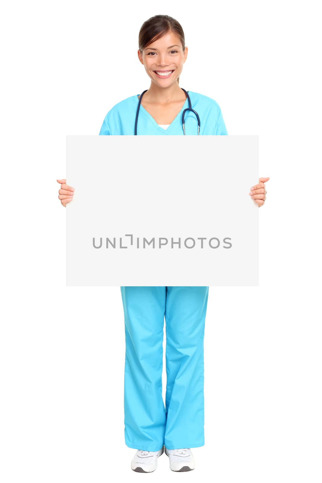 Nurse showing medical sign billboard standing in full length. Young smiling nurse or doctor in scrubs showing empty blank sign board with copy space. Asian Caucasian female model isolated on white background.