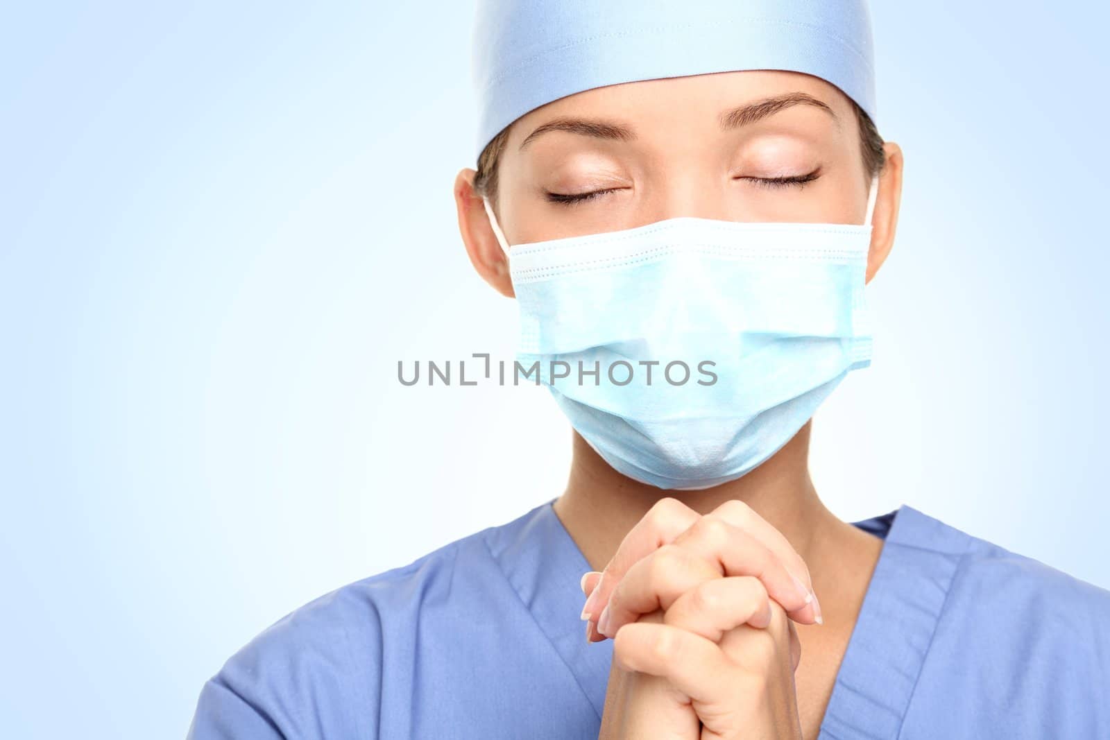 Doctor praying for help. Young woman medical doctor surgeon or nurse portrait.