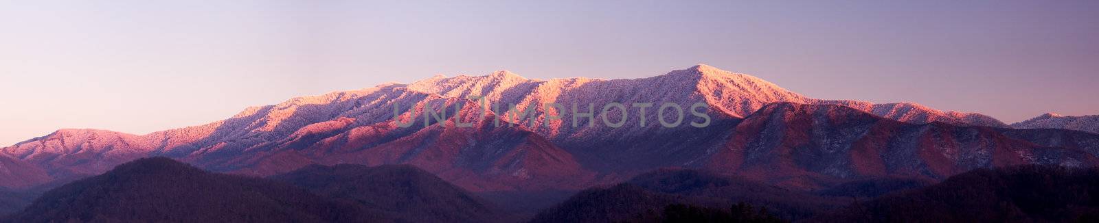 Sun setting on the Smoky mountains covered in snow above the town of Gatlinburg at dusk