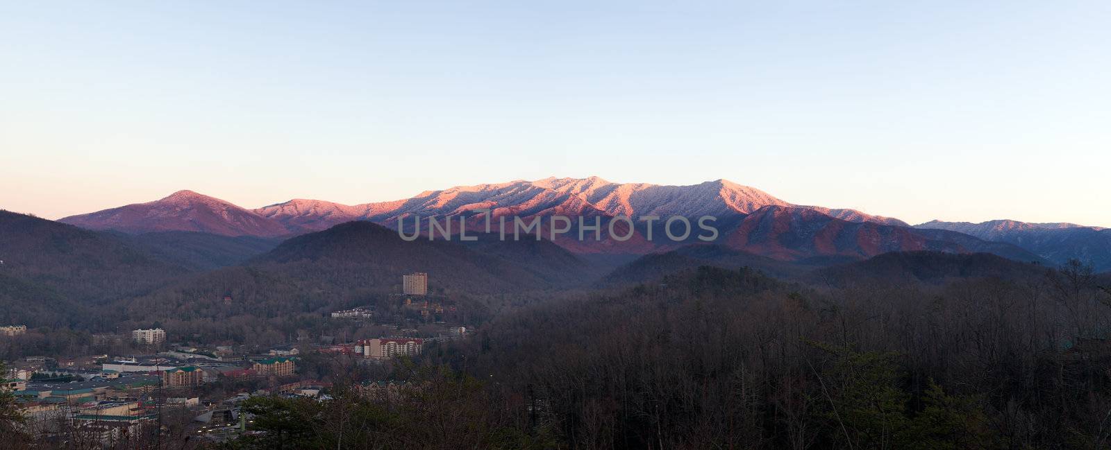 Sun setting on the Smoky mountains covered in snow above the town of Gatlinburg at dusk