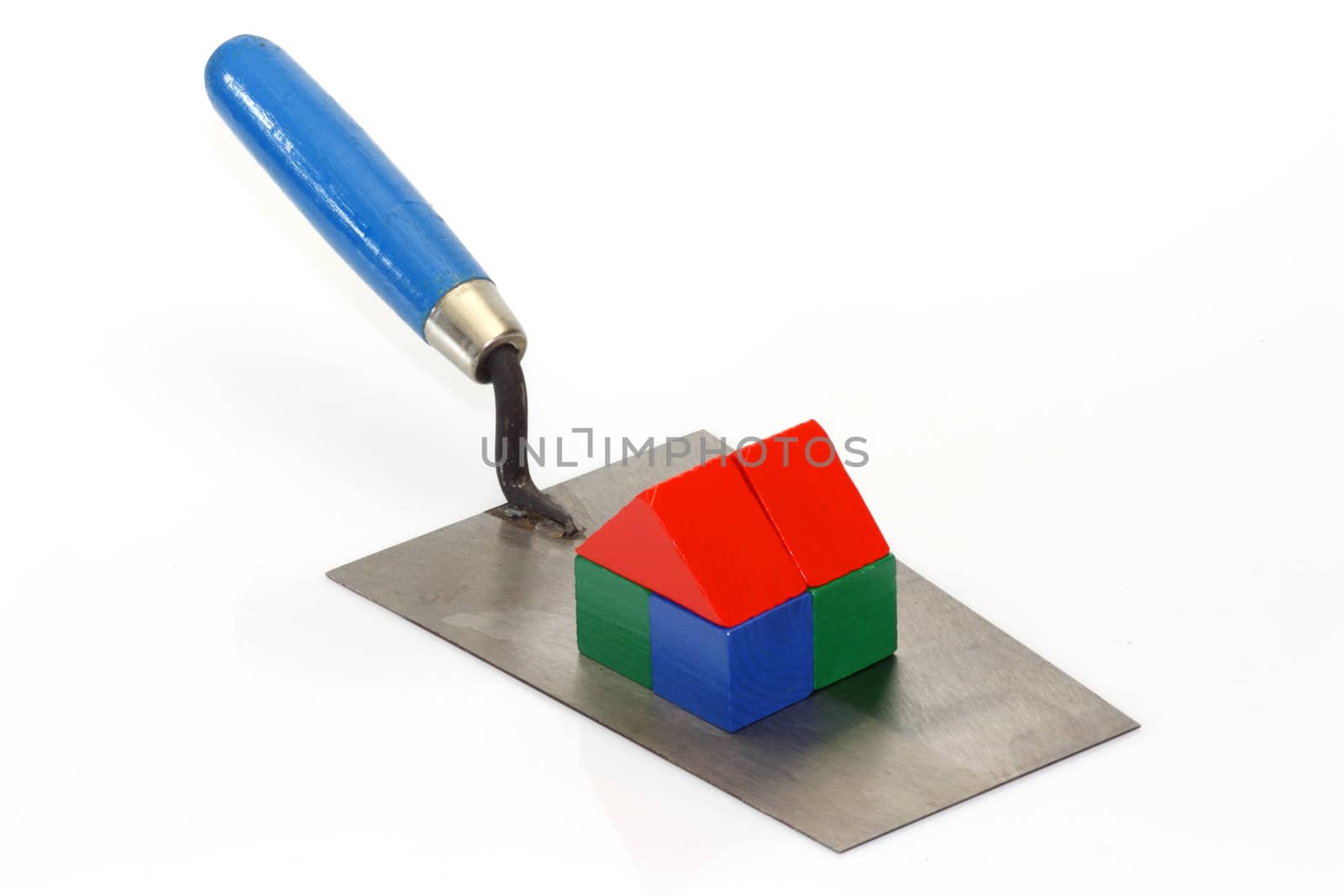 Trowel with toy bricks on bright background