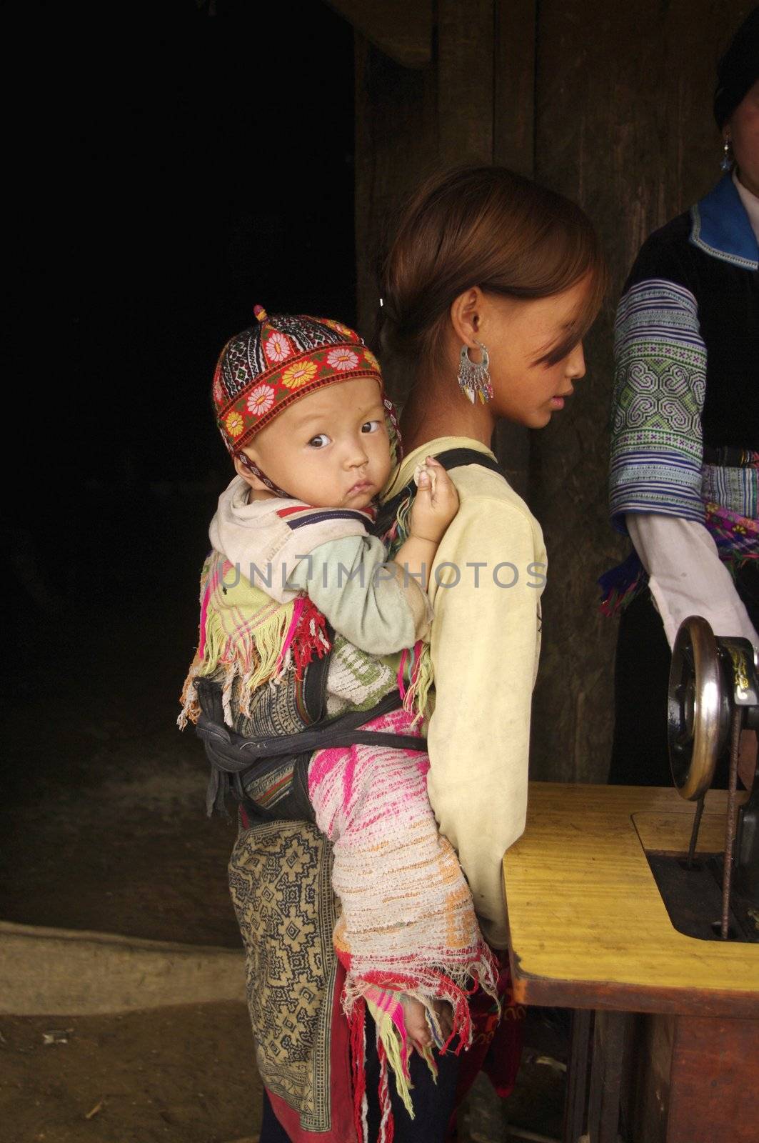 Since their very young age girls are accustomed to bear children in the back. In many families in northern Vietnam are often the elders who carry the new born.