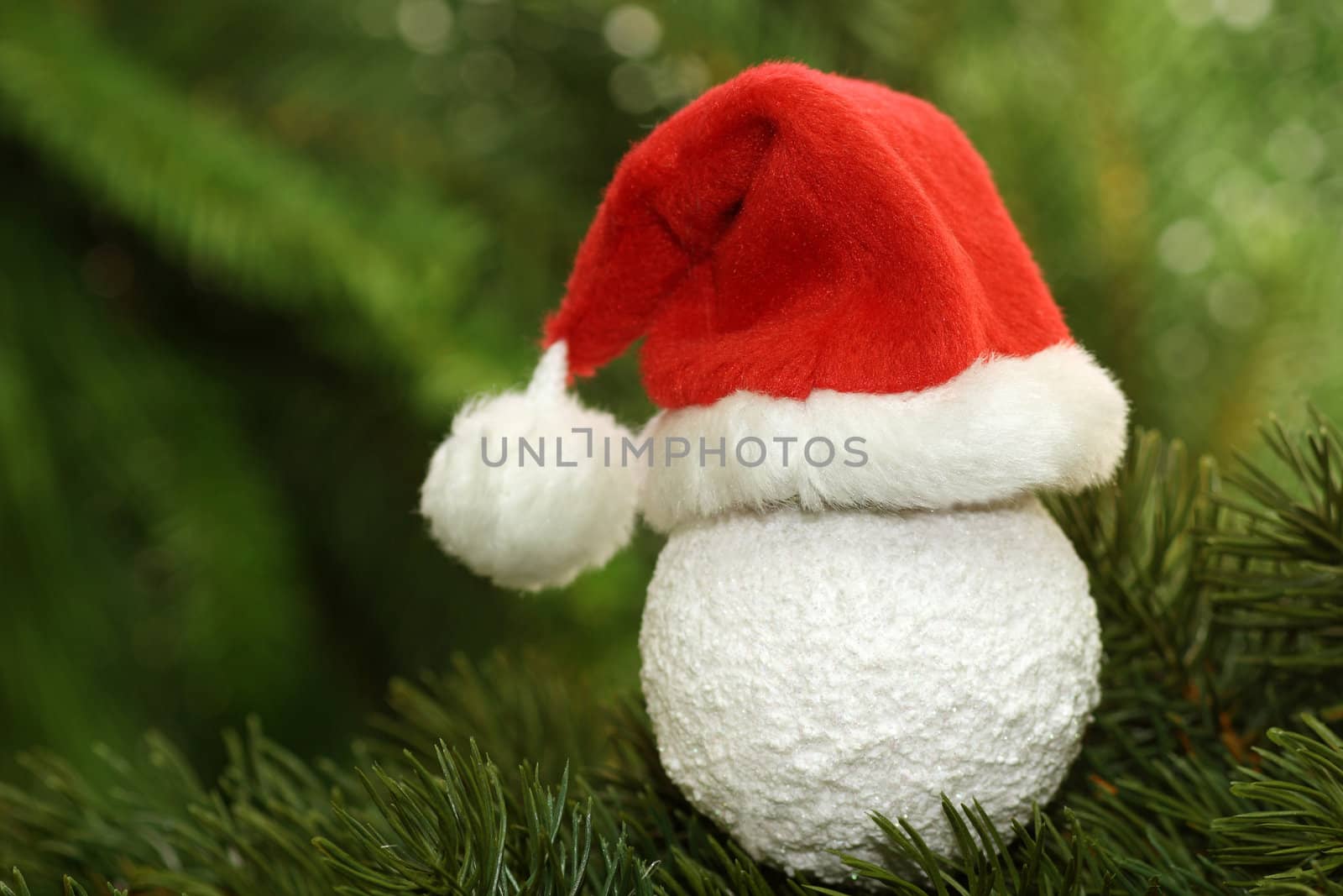 Christmas tree ball with santa claus cap  on green background