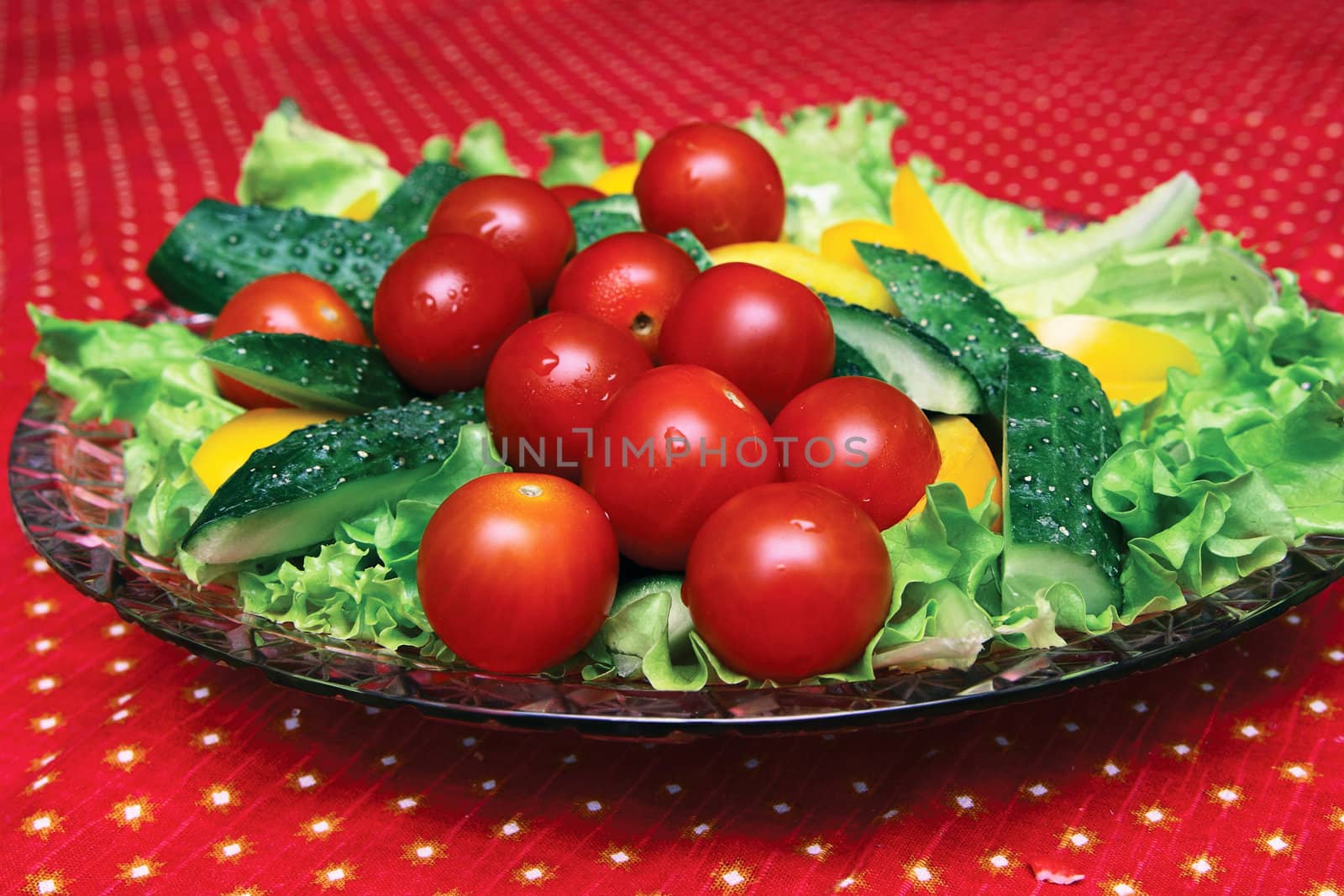 Fresh vegetables on a crystal dish on the table with a red cloth