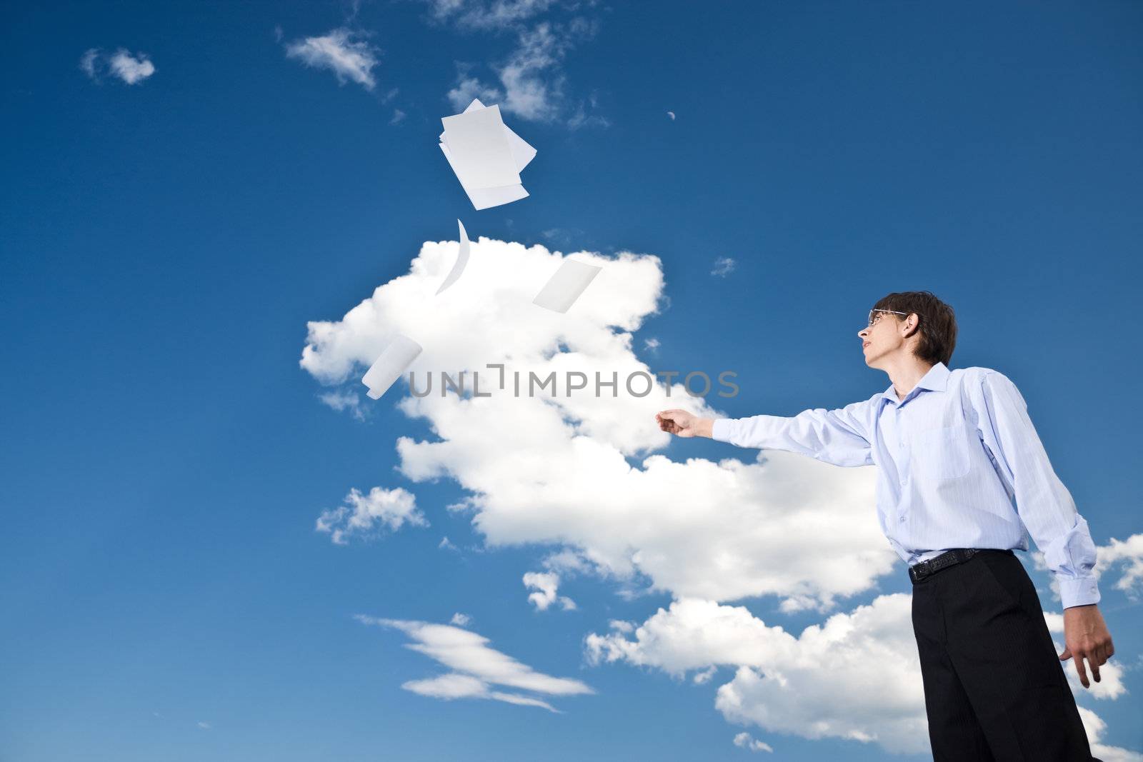 Young businessman tossing documents in the sky