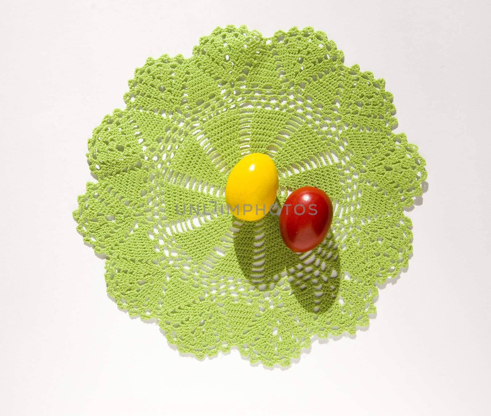 Colorful Easter eggs on a knitted green tissue isolated on a white background