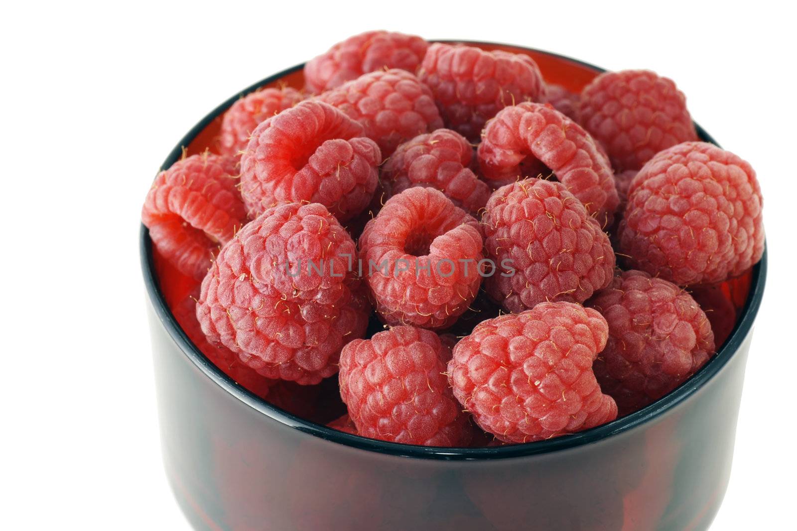 One serving of beautiful and delicious ripe raspberries in a red glass bowl on white background.