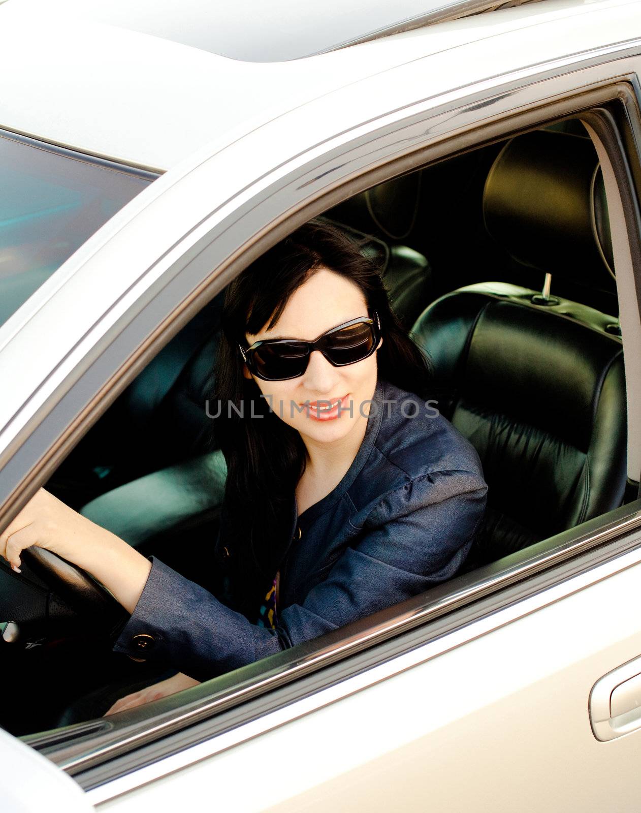 Beautiful young businesswoman in her car after work by fxquadro