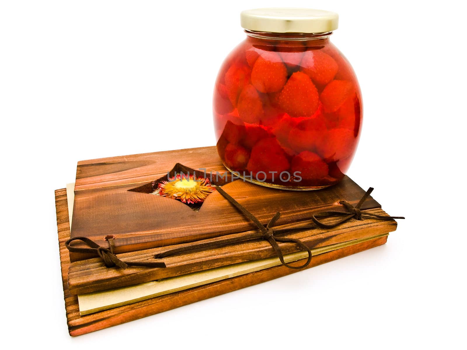 jar with red compote at ancient wooden desk against the white background