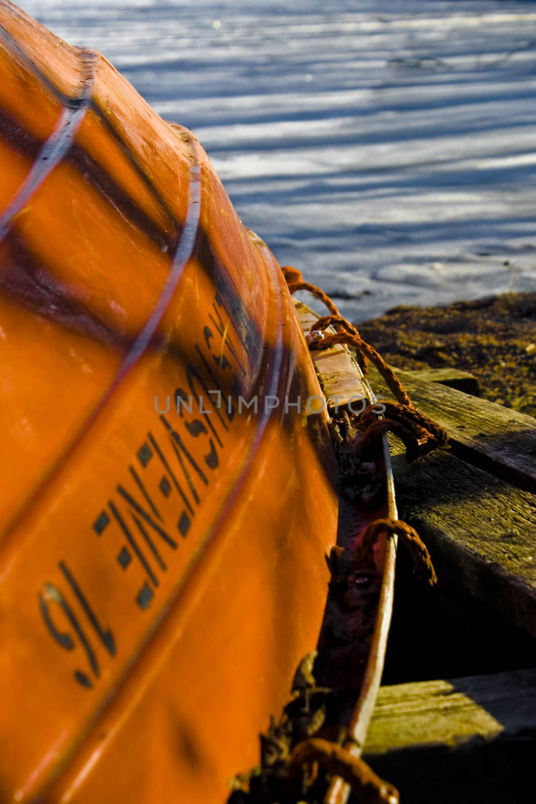 rowboat in orange in front of a sea