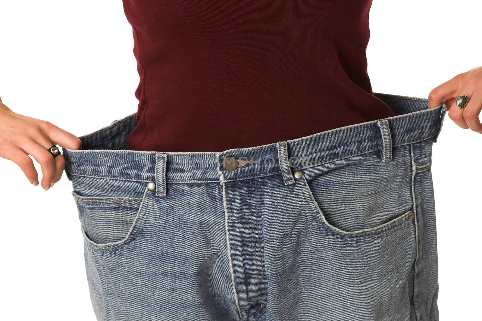 Woman showing how much she has lost by putting on an old pair of jeans