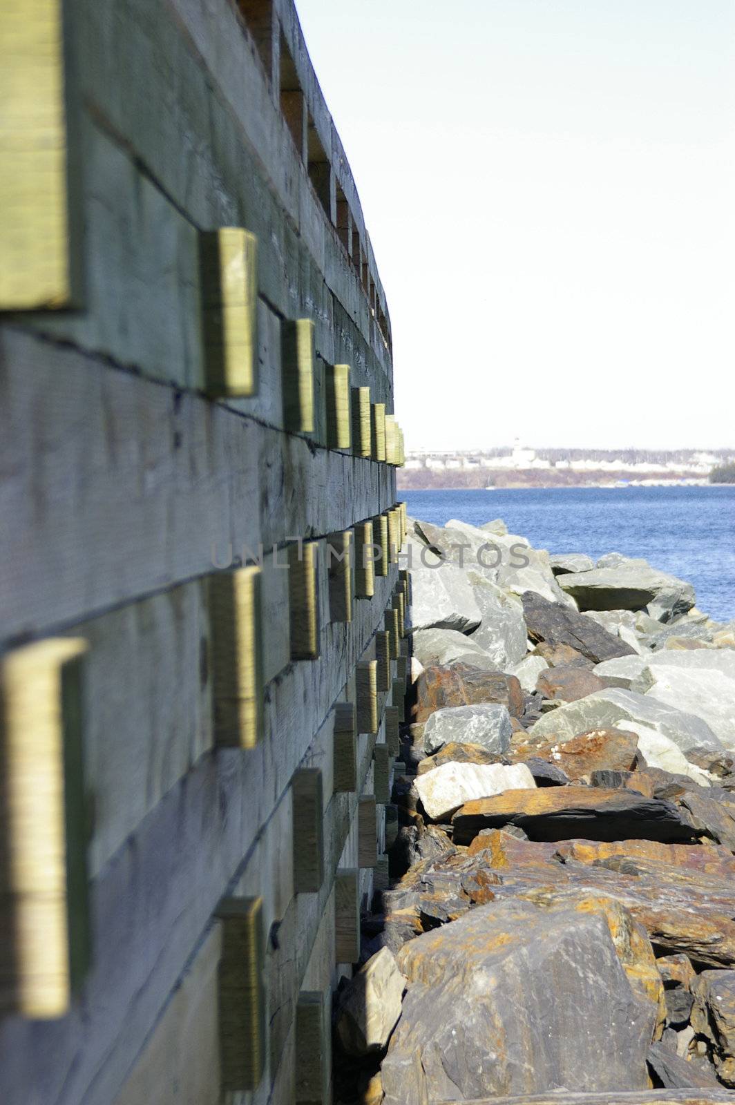 A side view of a boardwalk along a rocky shore line